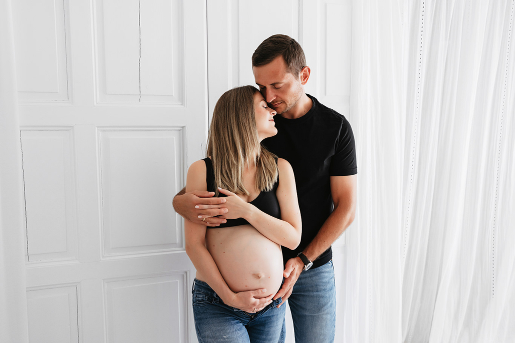babybauch15 Ein Paar bei einem schlichten und warmen Babybauchshooting im Studio, in liegenden und sitzenden Posen, liebevoll und natürlich festgehalten
