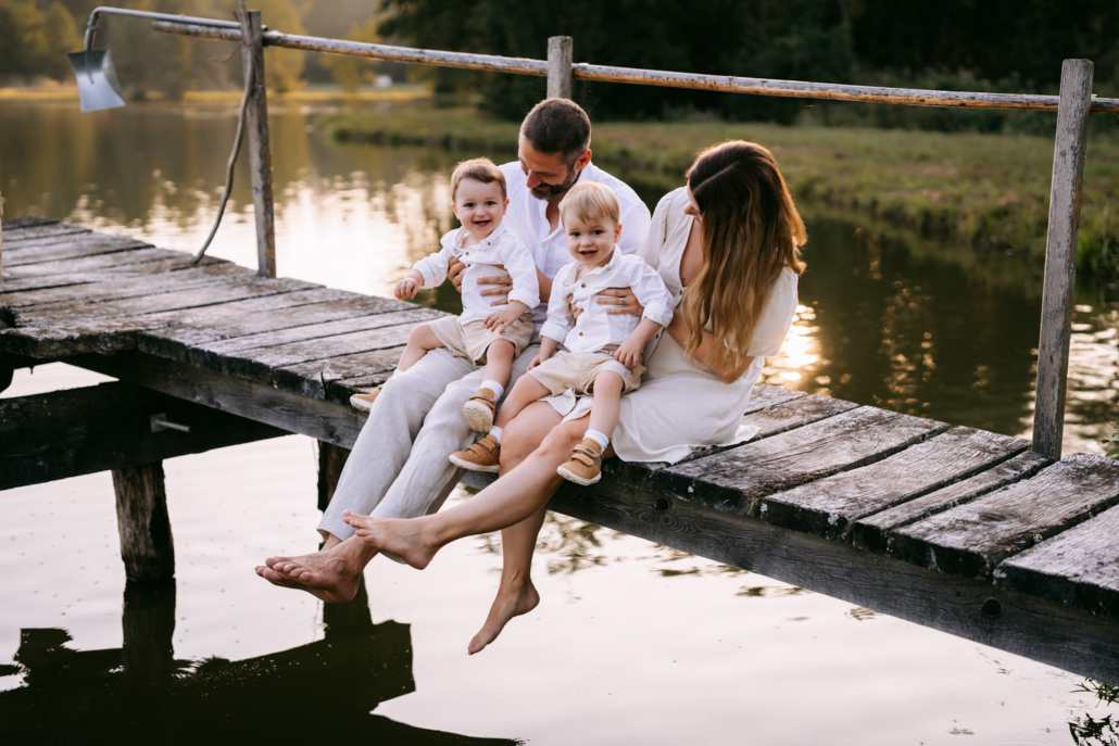familienfotos-13 Eltern mit ihren Zwillingen bei einem warmen Sonnenuntergang im Sonnenblumenfeld