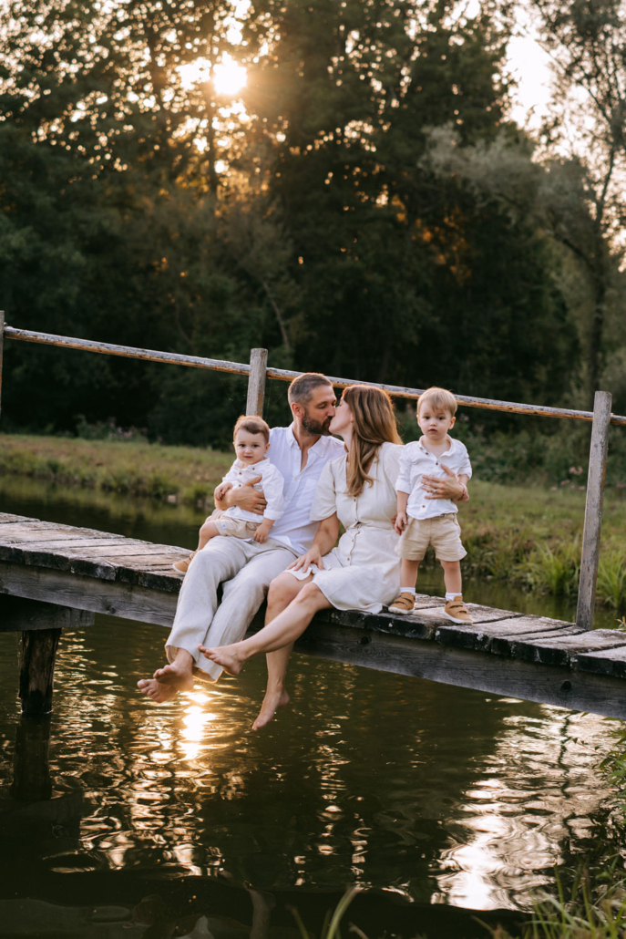 familienfotos-14 Eltern mit ihren Zwillingen bei einem warmen Sonnenuntergang im Sonnenblumenfeld