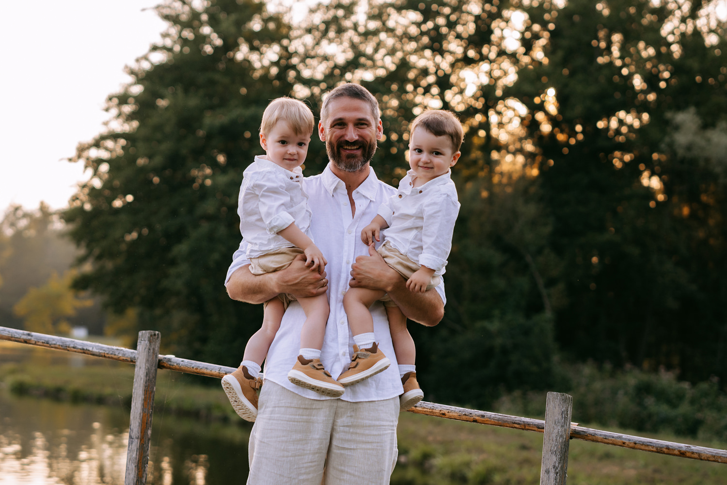 familienfotos-15 Eltern mit ihren Zwillingen bei einem warmen Sonnenuntergang im Sonnenblumenfeld