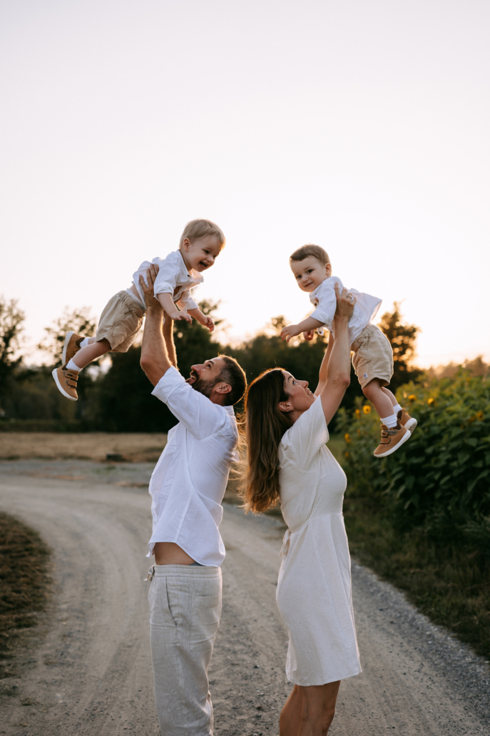 familienfotos-16 Familie mit Zwillingen im Freien bei Sonnenuntergang inmitten von Sonnenblumen