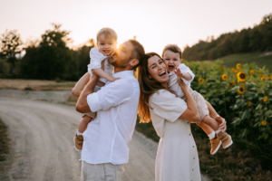 familienfotos-17 Familie mit Zwillingen im Freien bei Sonnenuntergang inmitten von Sonnenblumen