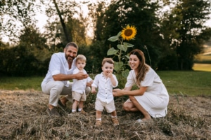 familienfotos-2 Familie mit Zwillingen im Freien bei Sonnenuntergang inmitten von Sonnenblumen