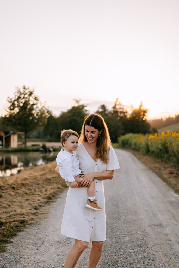 familienfotos-21 Eltern mit ihren Zwillingen bei einem warmen Sonnenuntergang im Sonnenblumenfeld