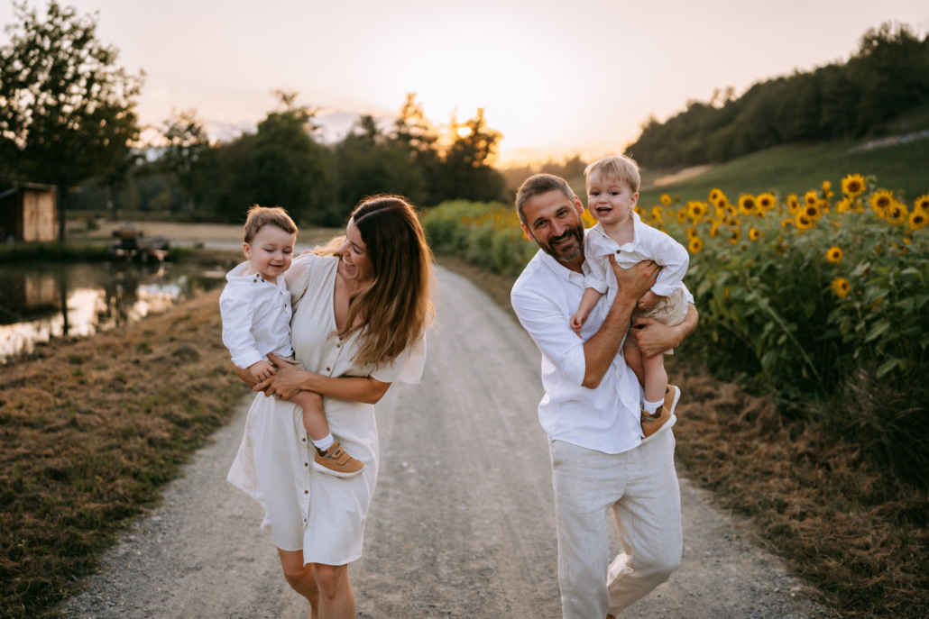 familienfotos-22 Familie mit Zwillingen im Freien bei Sonnenuntergang inmitten von Sonnenblumen