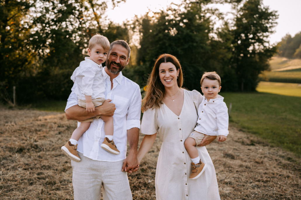 familienfotos-5 Zärtliche Familienmomente mit Zwillingen und ihren Eltern im Sonnenblumenfeld beim Sonnenuntergang