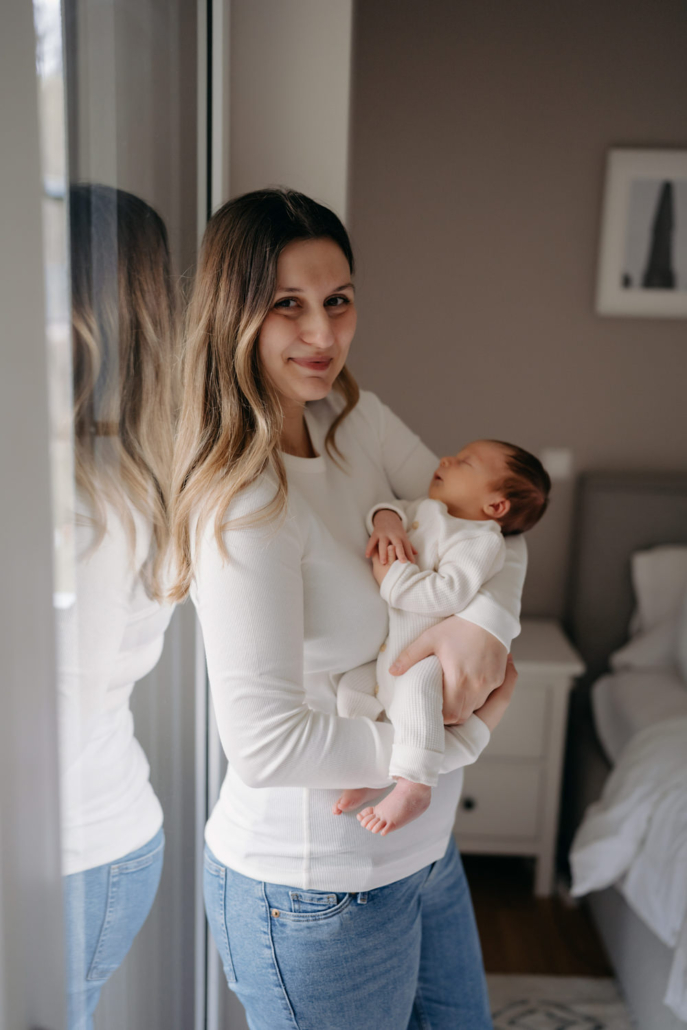 homestory-16 Neugeborenes schläft in den Armen der Mutter bei einer Homestory in der Steiermark. Zeitloses und schlichtes Neugeborenenshooting.