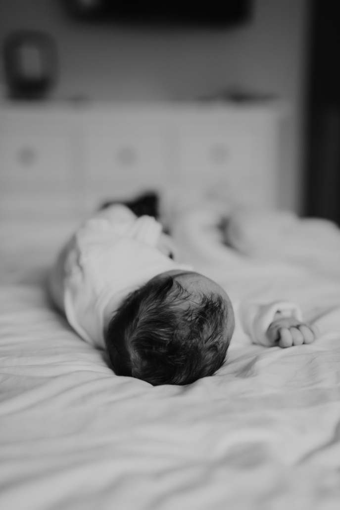 homestory-20 Neugeborenes schläft in Bett bei einer Homestory in der Steiermark. Zeitloses und schlichtes Neugeborenenshooting.