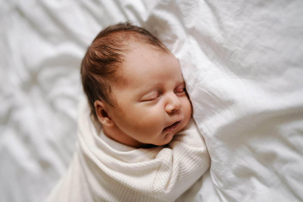 homestory-25 Neugeborenes schläft in Bett bei einer Homestory in der Steiermark. Zeitloses und schlichtes Neugeborenenshooting.